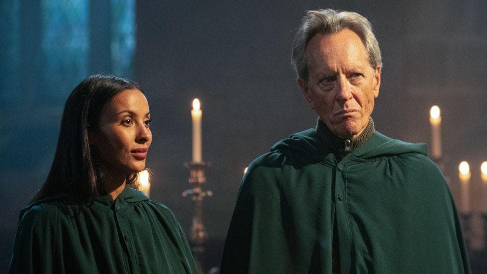 Maya Jama and Richard E Grant wearing the traitors' green cloak