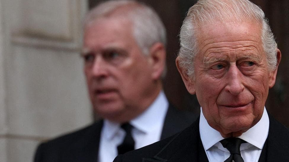 King Charles in the foreground of the image looks away to the left of the frame, whilst his younger brother Andrew Mountbatten Windsor is seen behind him, slightly out of focus.