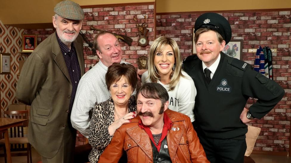 Six people pose as characters towards the camera