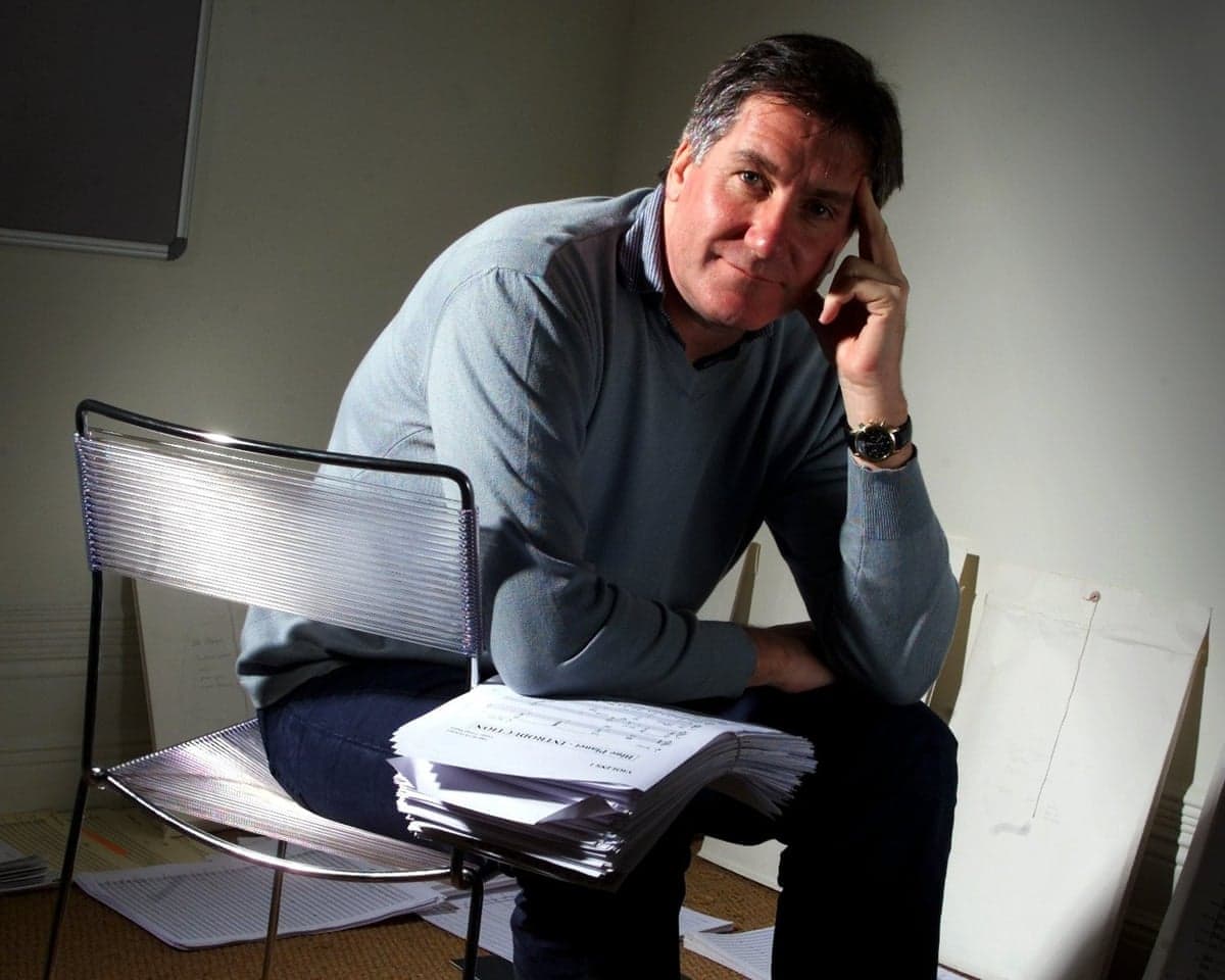 Composer George Fenton, pictured in 2001, rests his head on his hand with sheet music on his lap