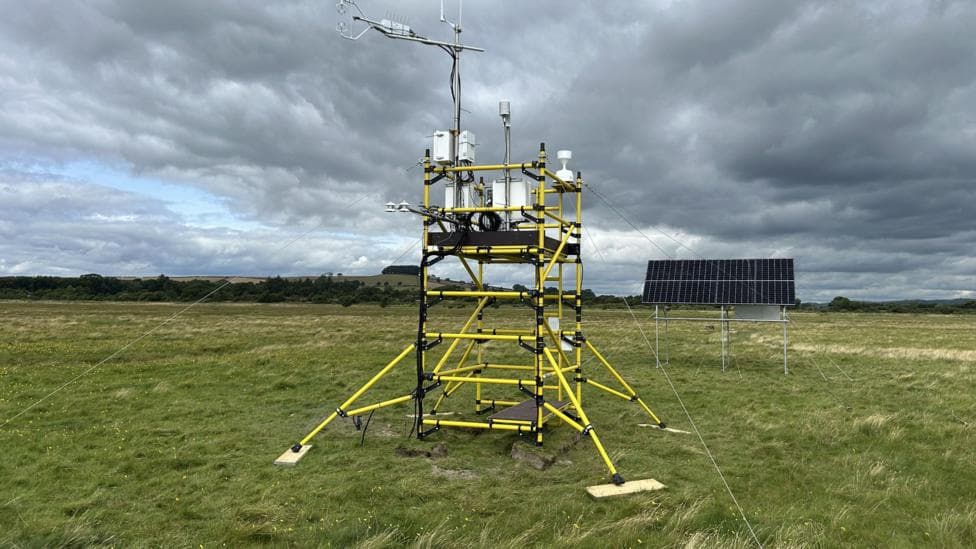 A carbon tracking tower - a yellow framed tower - sitting on saltmarsh in the south of Scotland