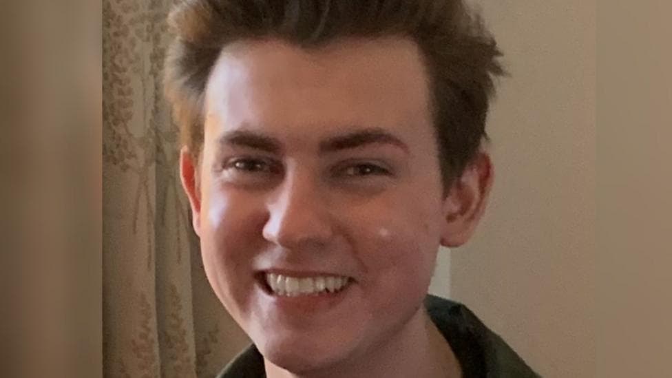 Ethan Brown has short, dark hair and is smiling broadly at the camera