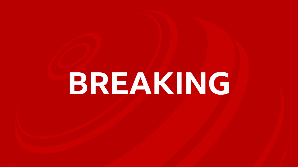 The word breaking written in white on a red background, with lighter red concentric circles