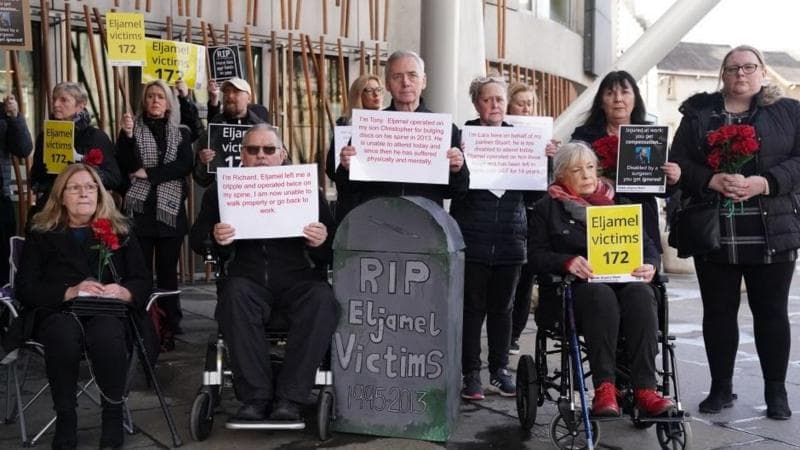 Protesters outside the Scottish Parliament in Edinburgh holding banners and cards about the disgraced surgeon Professor Sam Eljamel