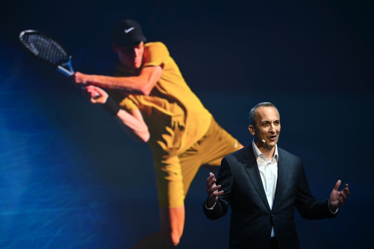Tennis Australia CEO Andrew Abdo speaks in front of an image of Jannik Sinner during a 2027 Australian Open launch event in Melbourne