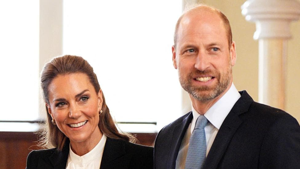 A woman with dark hair smiling and man with beard