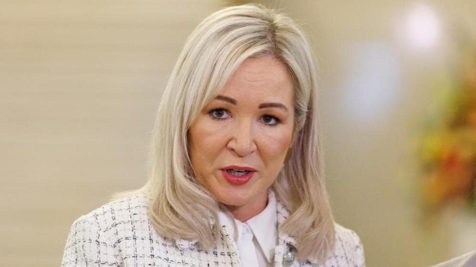 Michelle O'Neill speaking in Stormont. She is wearing a white blazer and shirt