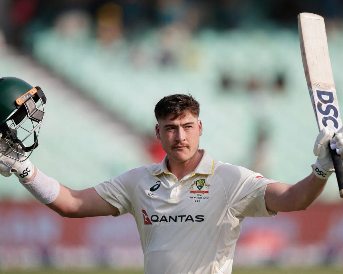 Matt Renshaw raises his helmet and bat with both arms, acknowledging the crowd