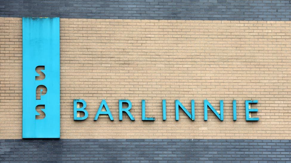 Close up of a sky blue "Barlinnie" and SPS signs set on the brick wall of a prison building