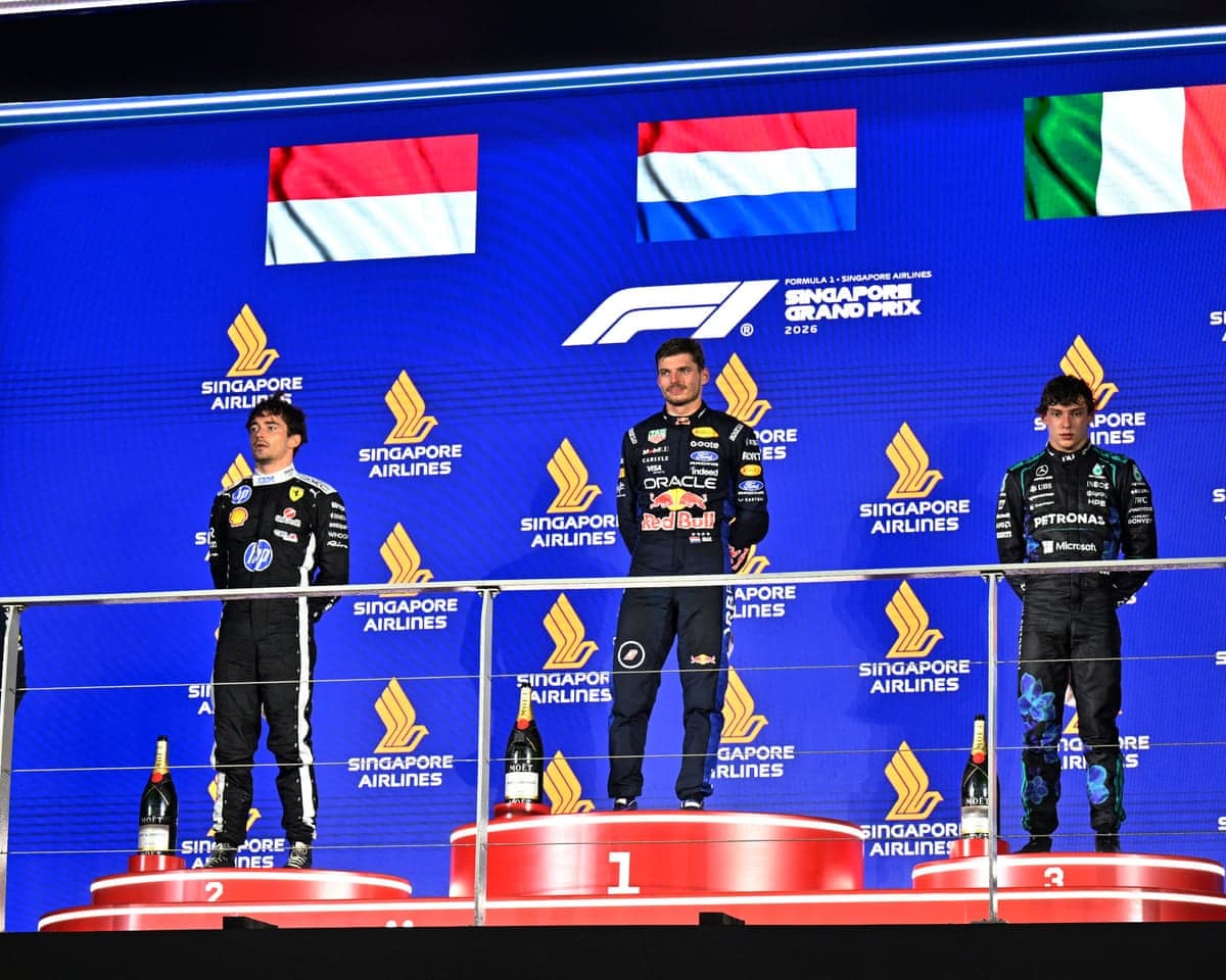 Max Verstappen on the podium alongside Charles Leclerc (left) and Kimi Antonelli (right).