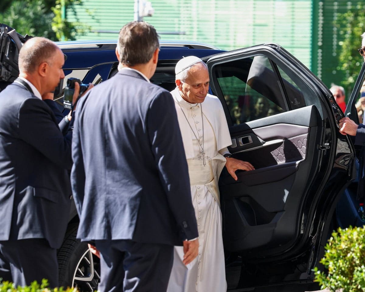 Pope Leo steps out of a car.