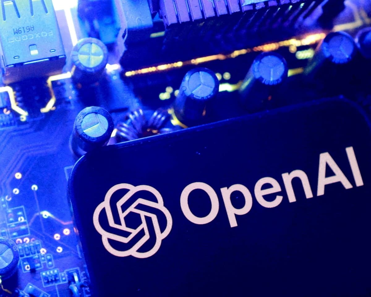 A close-up of an OpenAI logo plaque on a circuit board, lit with blue light