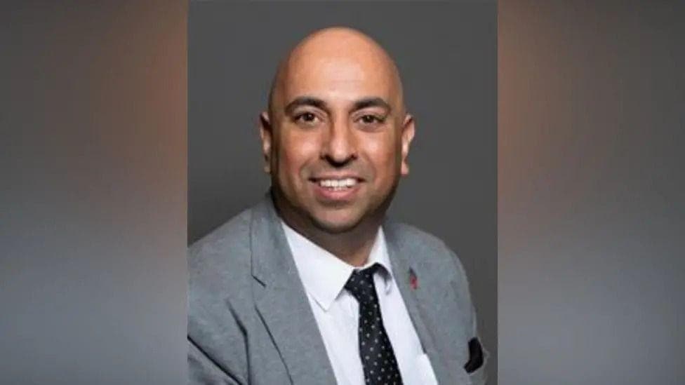 A portrait image of a councillor wearing a tie and grey suit jacket and white shirt