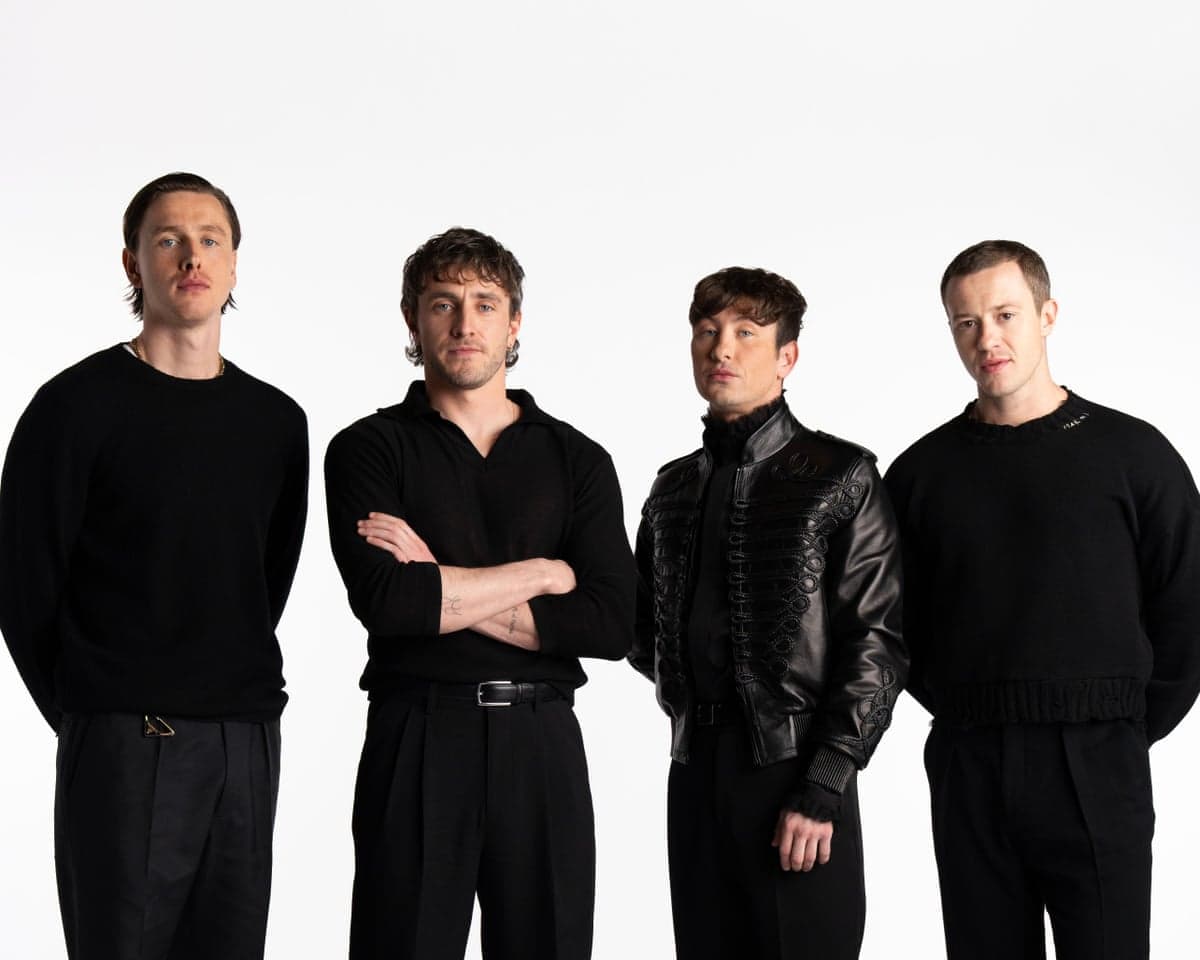 Actors Harris Dickinson, Paul Mescal, Barry Keoghan and Joseph Quinn stand in a line, all dressed in black, against a white background