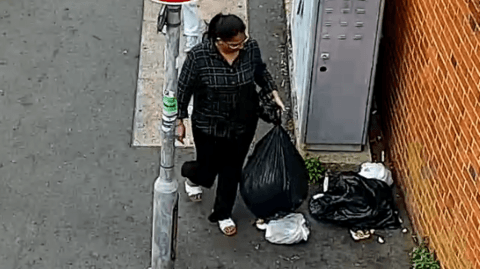 Woman drops bag of rubbish on pavement