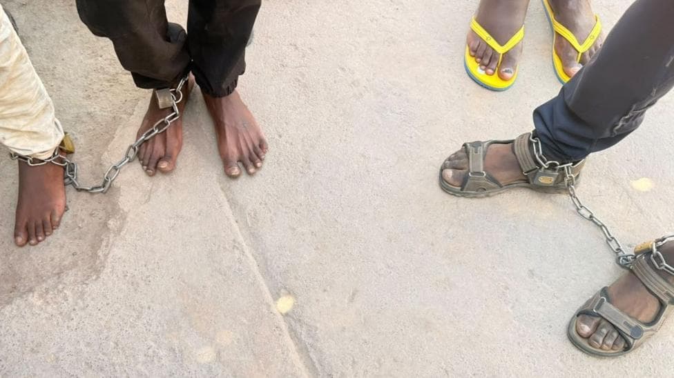 Men are seen with chains around their feet after they were found at a suspected rehab facility in South Africa