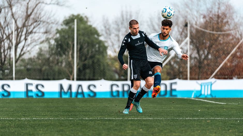 Two soccer players in action during an intense match, competing for the ball outdoors.