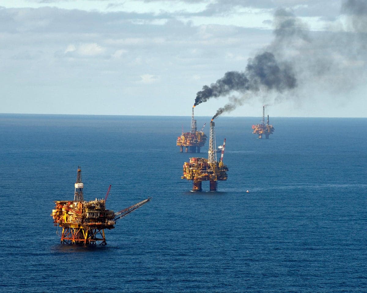 Aerial view of oil platforms in the North Sea's Brent oilfield, one emitting dark smoke