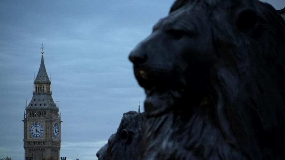 Foreground of the head of a Trafalgar Square Lion with the Elizabeth Tower of the Houses of Parliament in the background