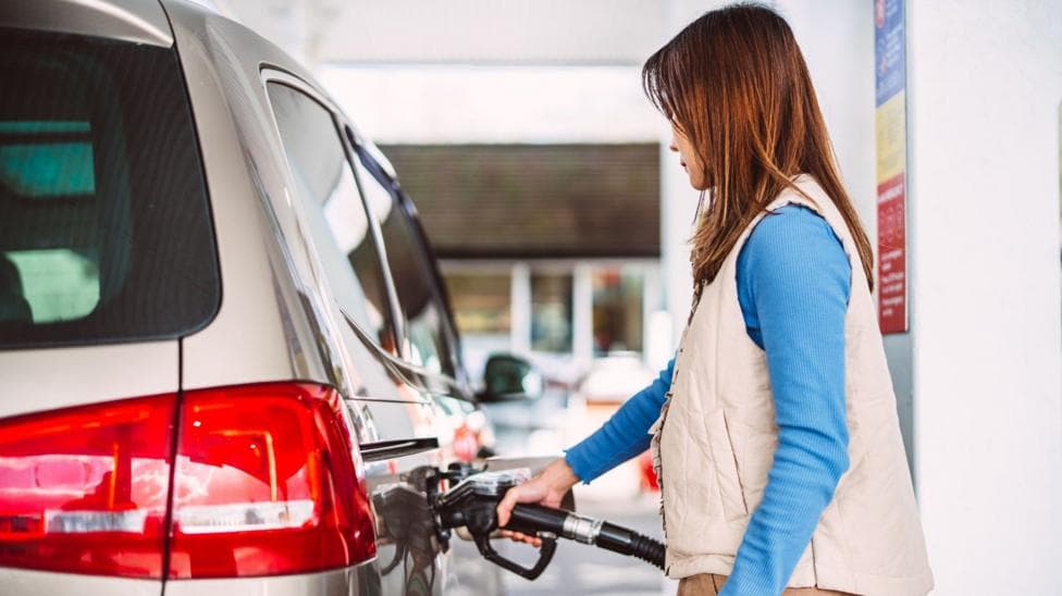 Woman fills a car with petrol - stock shot