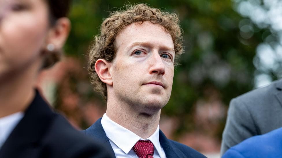 Meta CEO Mark Zuckerberg standing outside of the White House, looking to the side, while surrounded by security people.