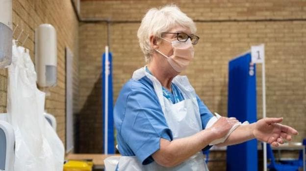 A health worker washes her hands after giving Pfizer-BioNTech Covid-19 vaccines at Cardiff and Vale Therapy Centre on December 8, 2020 in Cardiff, Wales. Wales joined the other UK nations in rolling out the covid-19 vaccine on Tuesday, a rare moment of coordination after months of disjointedness in the four nations' pandemic response. Wales introduced a 17-day "firebreak" lockdown in October and November to suppress the surge in covid-19 cases, but infections have continued to rise. (Photo by Matthew Horwood/Getty Images)