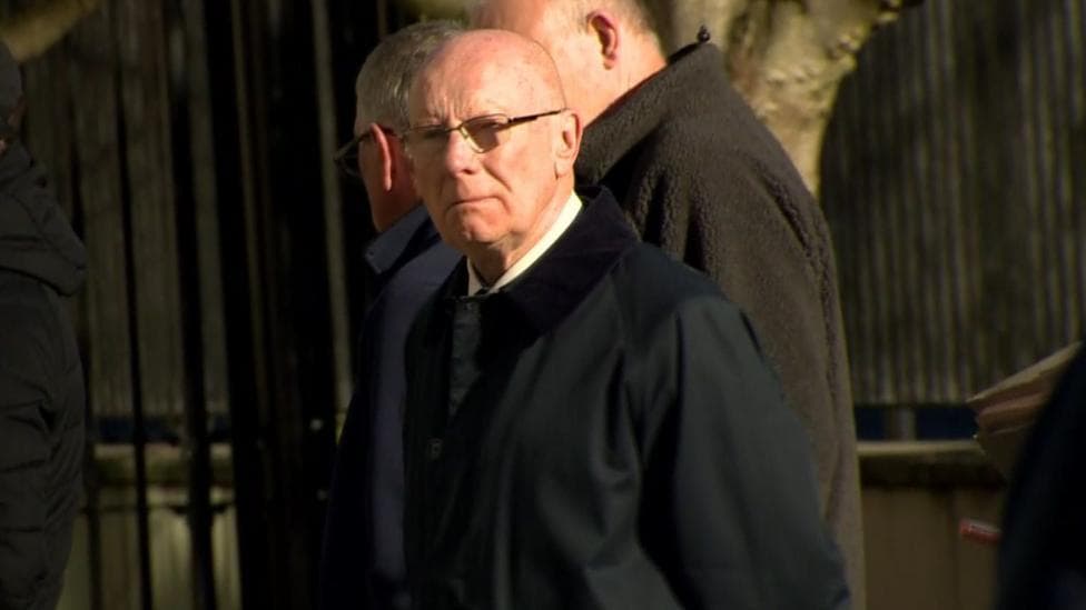 A man wearing glasses and a black coat