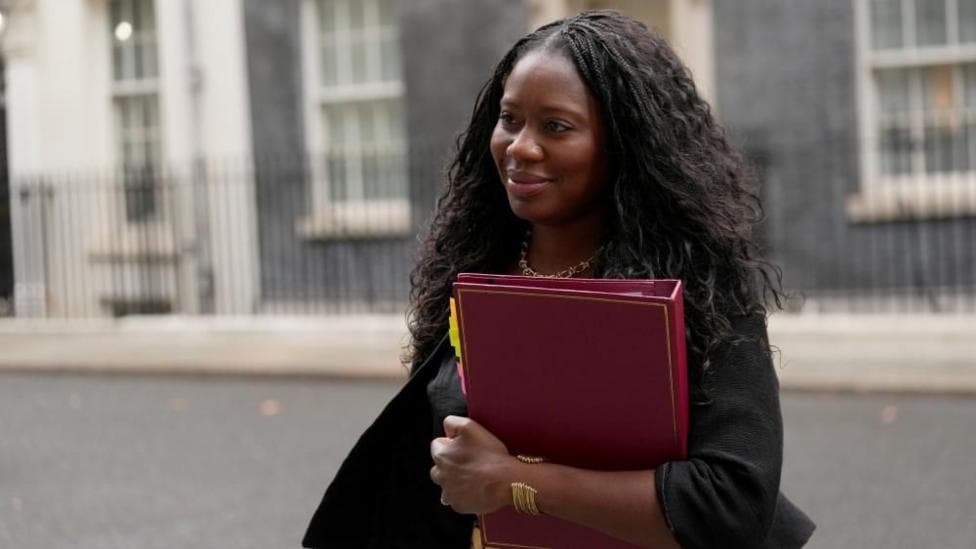 Miatta Fahnbulleh walks in Downing Street while holding a red folder.