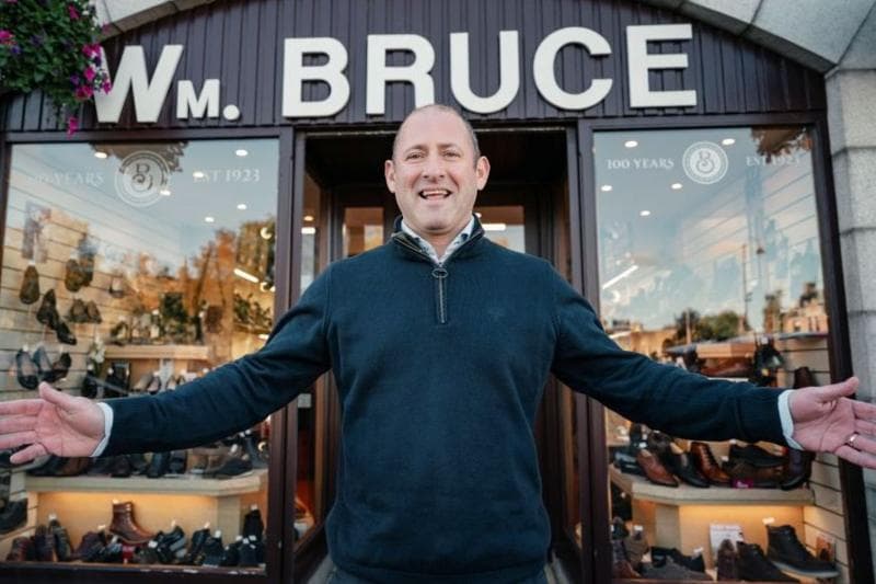 A local Inverurie businessman Stephen Bruce, smiling at the camera, with his arms open wide.