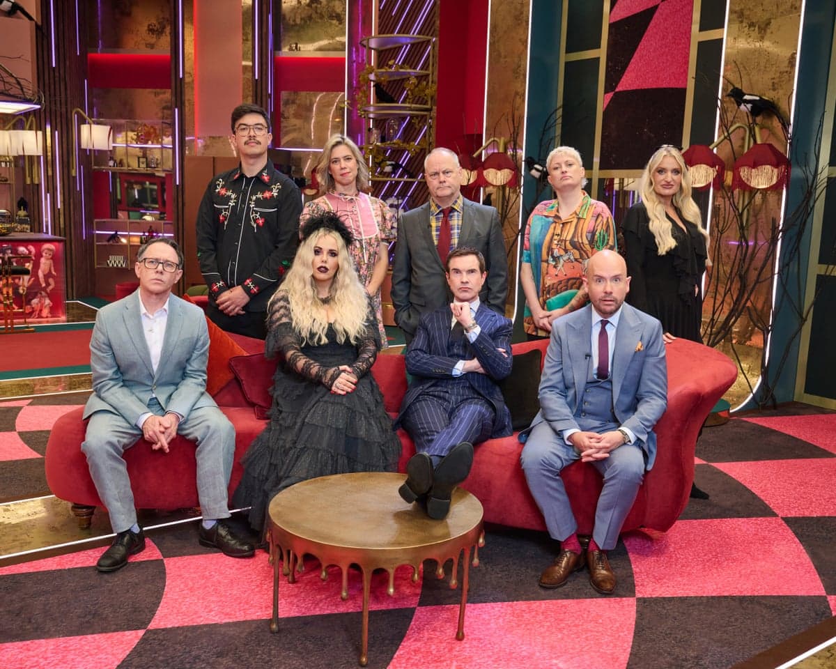 Last One Laughing Halloween cast pose in formal attire and Gothic costumes around a red sofa
