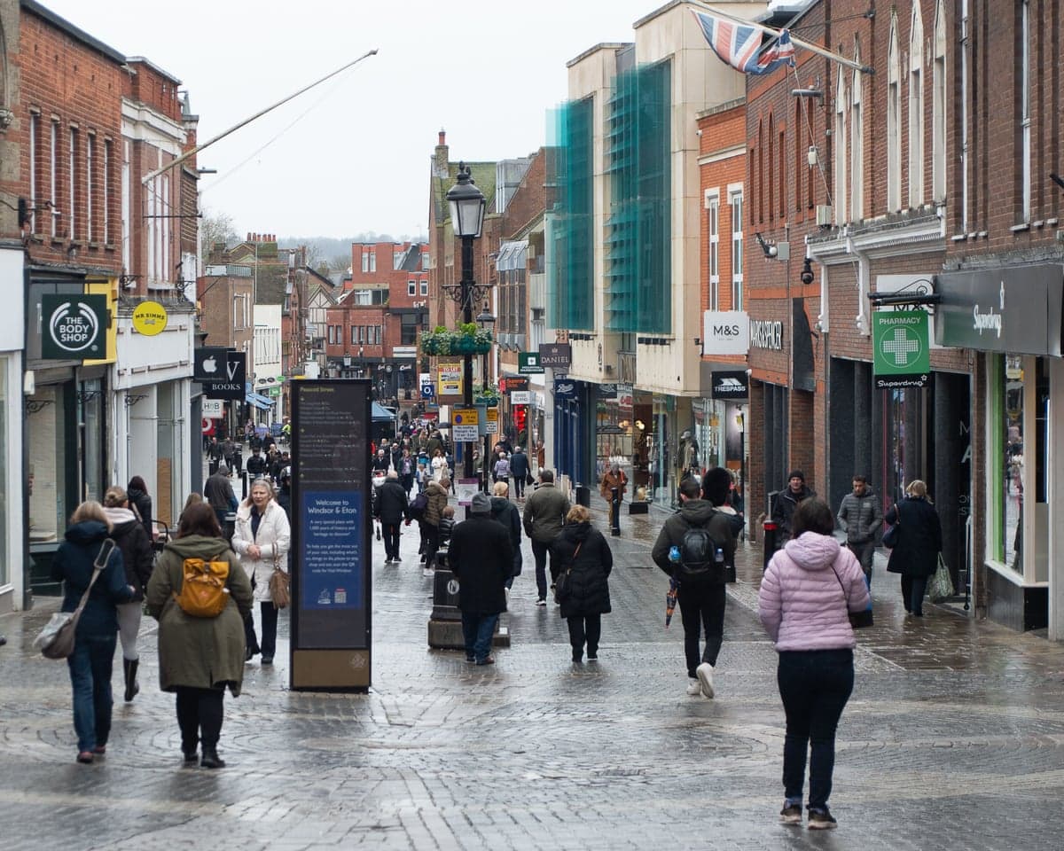 Shoppers on a high street in England on a rainy morning