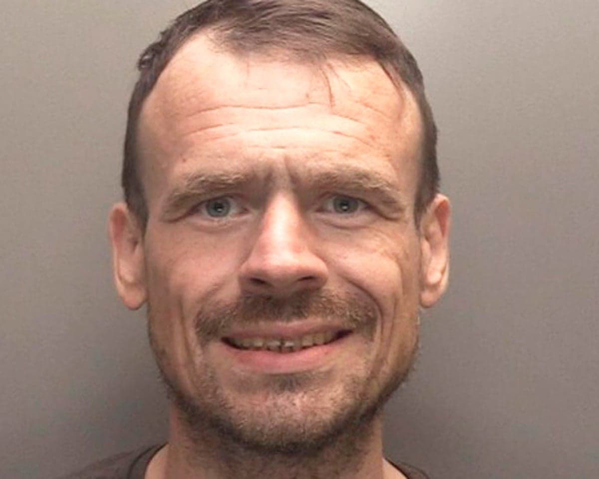 Anthony Lloyd, wanted after absconding from custody, smiles in a police mugshot photo