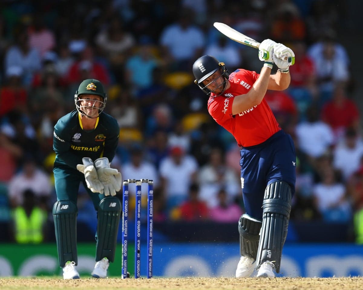 Jos Buttler swings his bat mid-shot as an Australian wicketkeeper watches behind the stumps