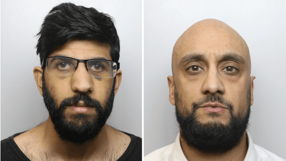 Two men pictured side by side in police mugshots. On the left, the man has spectacles, a dark beard and bruising underneath his eyes. On the right, the man is bald and has a dark beard.
