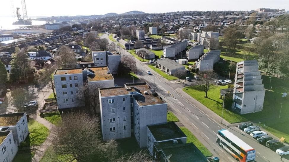 An aerial view of a street with blocks of flats on either side