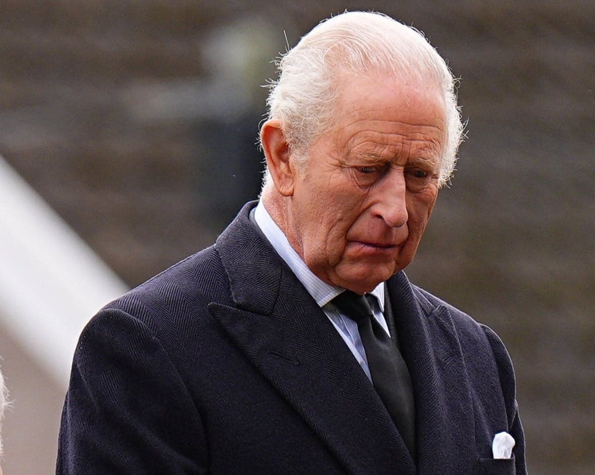 King Charles attends a commemoration event at Aberfan last week. He wears a black coat and tie and has his eyes downcast, looking sombre.