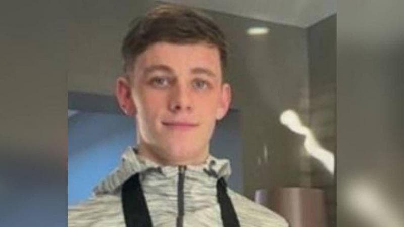 Tristan Kerr wearing a light grey zipped top. He has short brown hair and smiles.