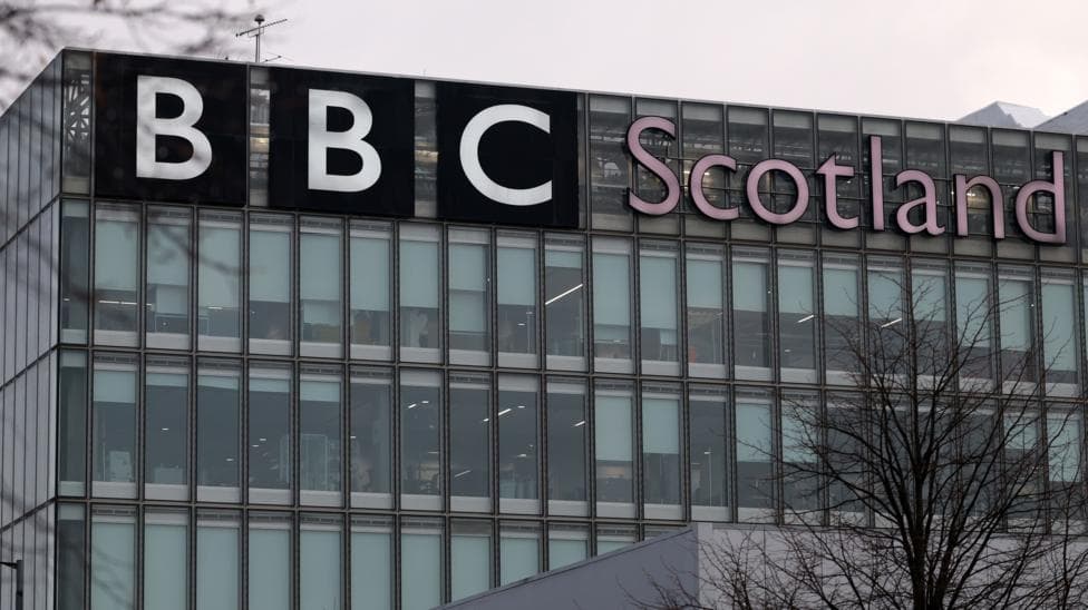 Close up of a rectangular building with lots of windows and a sign saying 'BBC Scotland'