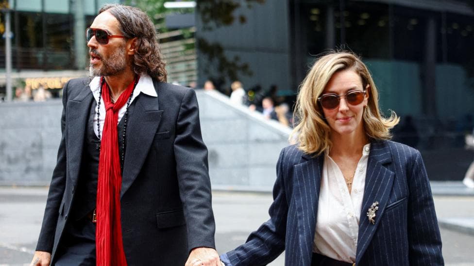 Russell Brand and Laura Brand holding hands and walking into court on Thursday
