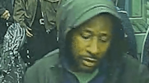 A CCTV image of Anthony Williams on a train. He is wearing a dark jacket and has his hood up.