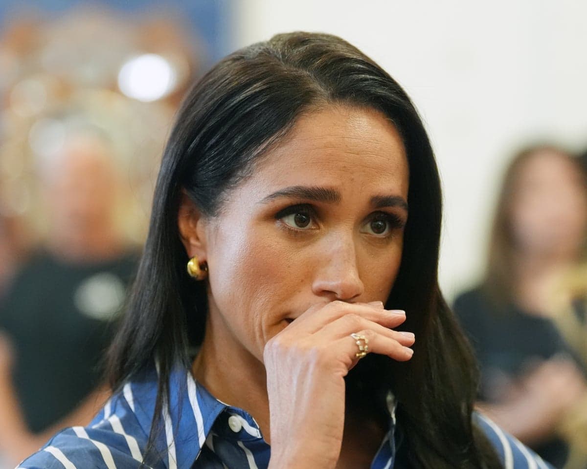 Meghan, Duchess of Sussex, presses her hand to her mouth, looking emotional