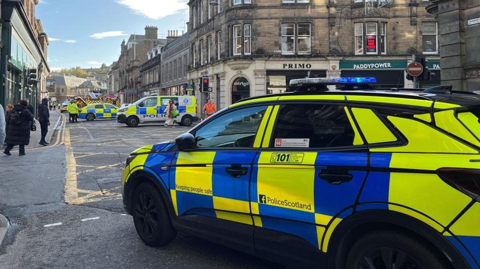 A police car in Academy Street, Inverness. There are other police vehicles further down the street.