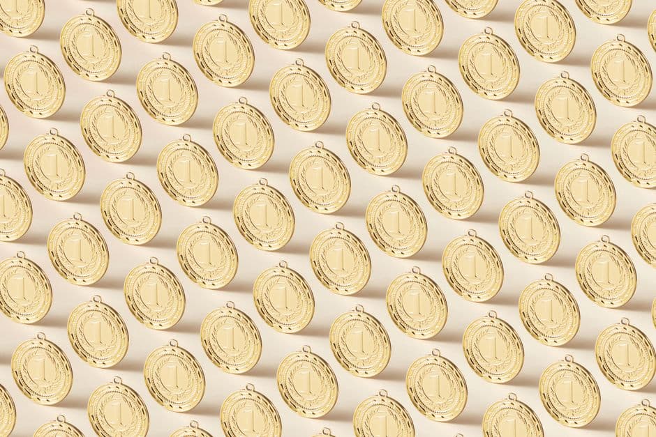 Seamless pattern featuring gold medals on a flat background, ideal for sports themes.