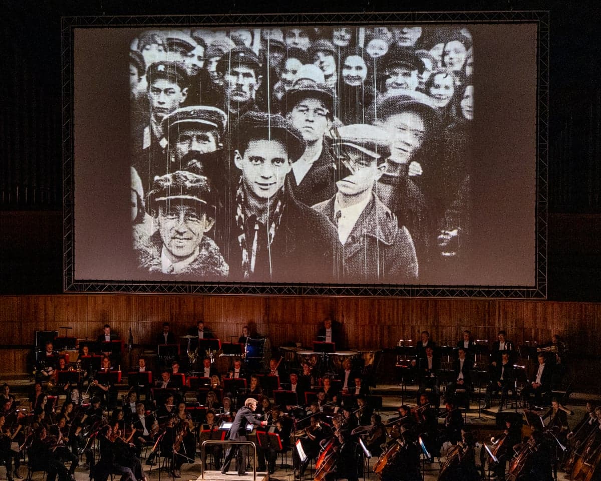 An image of the Philharmonia Orchestra, conducted by Marin Alsop, playing Shostakovich's 10th Symphony alongside William Kentridge's film Oh to Believe in Another World in April 2025