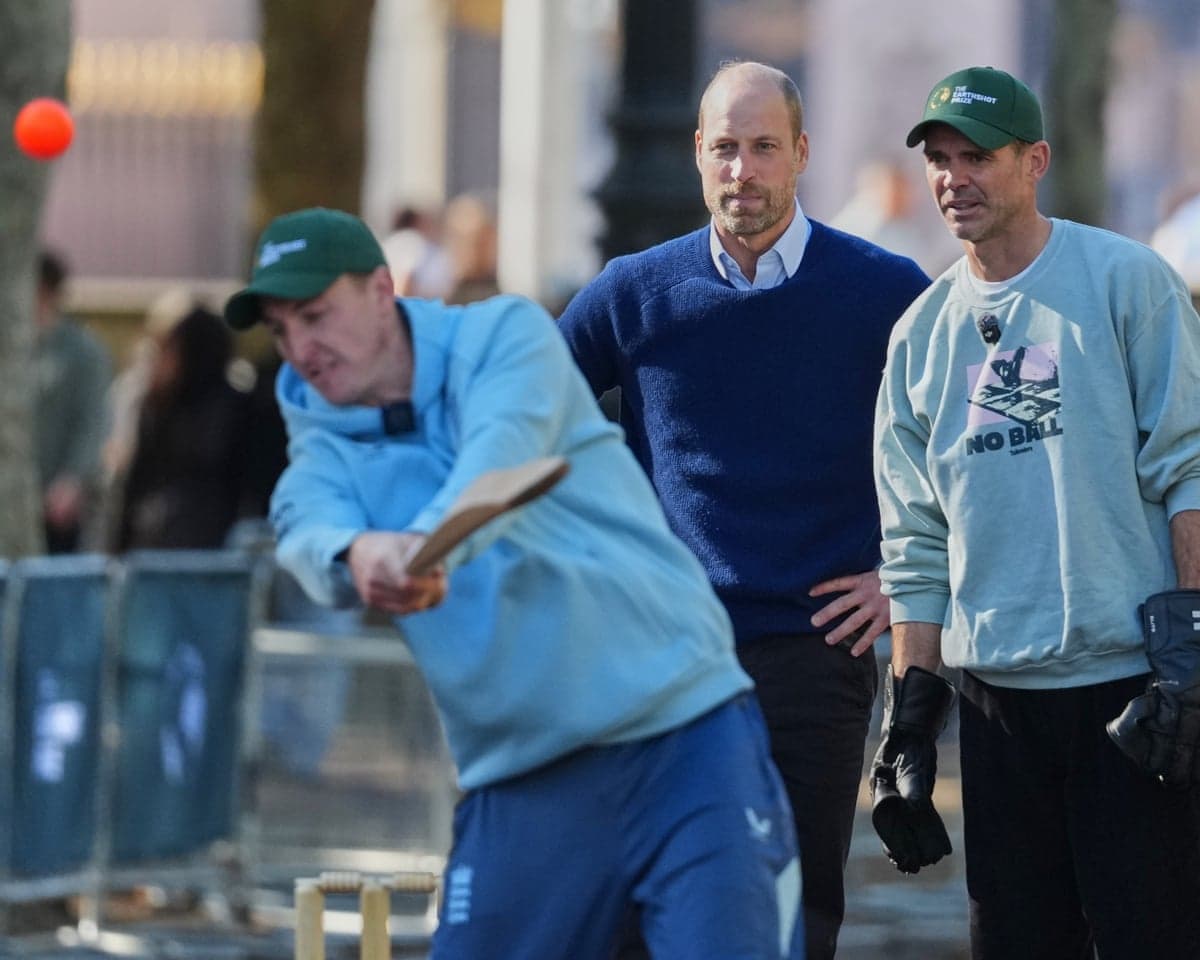 Jimmy Anderson, right, and Prince William watch as Harry Brook swings a bat during an outdoor match on The Mall.