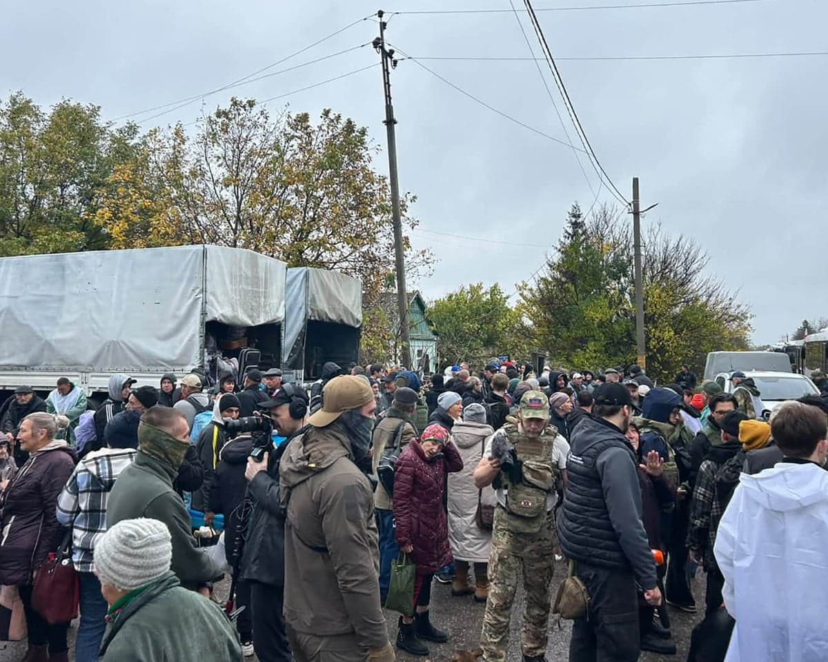 Crowds awaiting evacuation gather near trucks