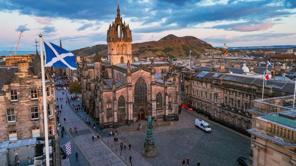 A general view of St Giles Cathedral in Edinburgh with a saltire flag on a pole in the foreground.
