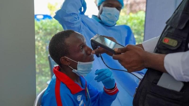 A man getting checked by a health professional who holds an implement up to him